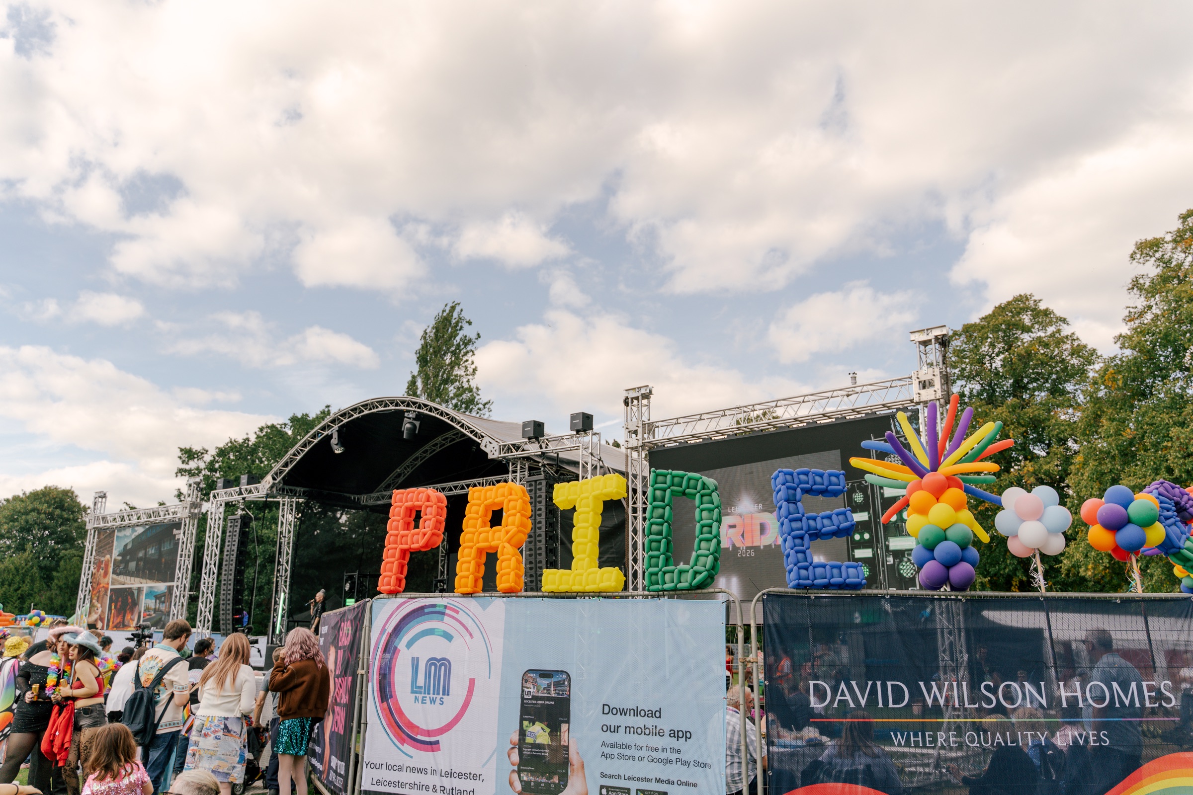 Leicester Pride 2026 stage with Pride balloon lettering and crowd barriers
